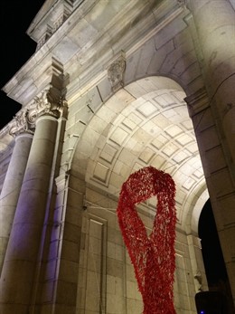 Un gran lazo rojo luce en la Puerta de Alcalá