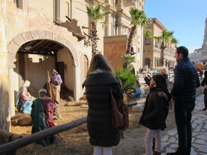 Una familia visita el belén de la Plaza del Pilar