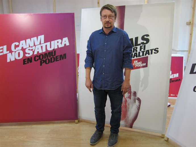Xavier Domènech (EnComúPodem), junto al cartel de campaña