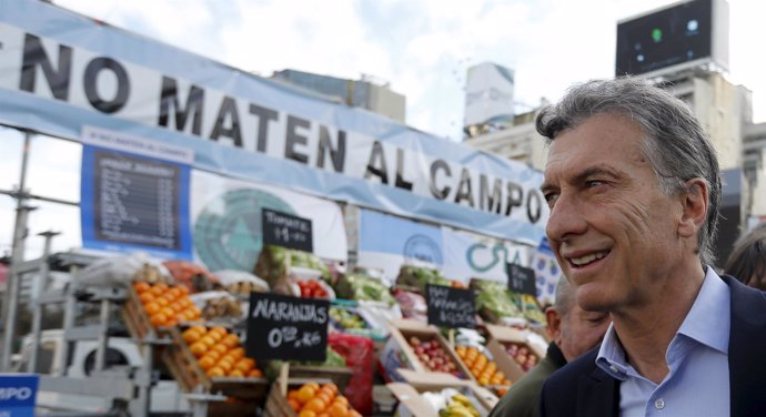 Presidential candidate Macri looks at products displayed by anti-government rura