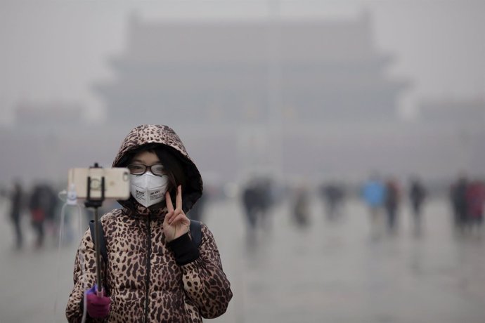 Una mujer lleva una mascarilla en la plaza de Tiananmen de Pekín