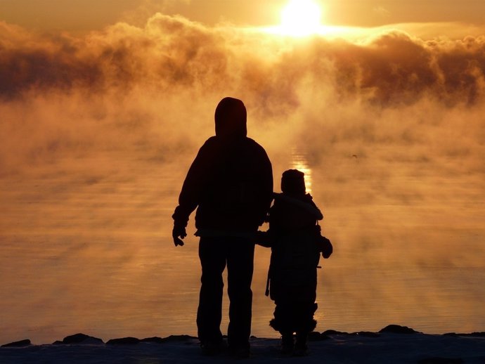 Silueta padre e hija con niebla