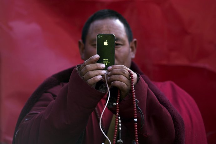 Monje tibetano budista con Iphone
