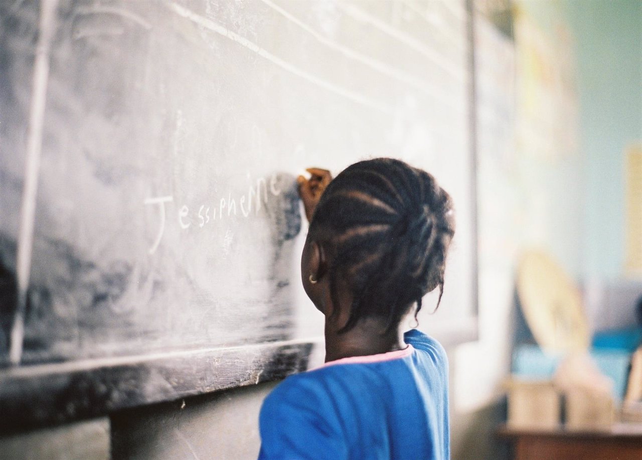 Niña escribiendo su nombre en una escuela de Sierra Leona