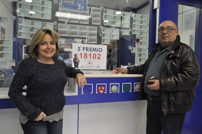 La lotera María Luisa García Lacal, de 'El búho repartidor', con un cliente