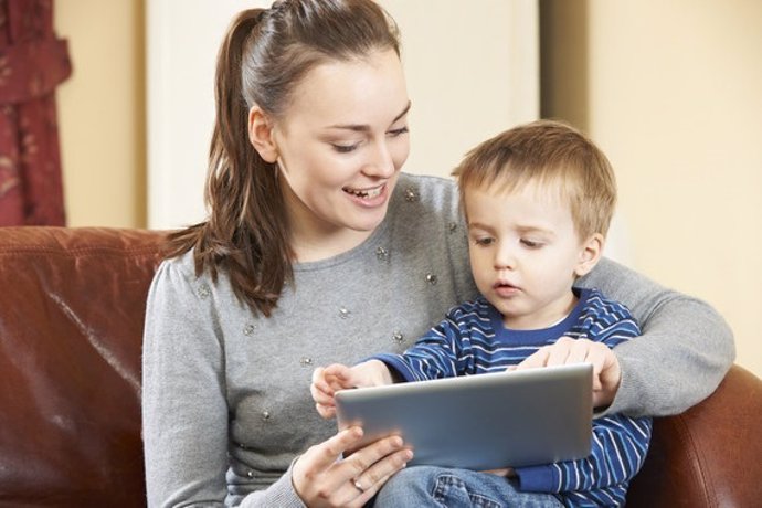 Mother And Son Playing On Digital Tablet Together