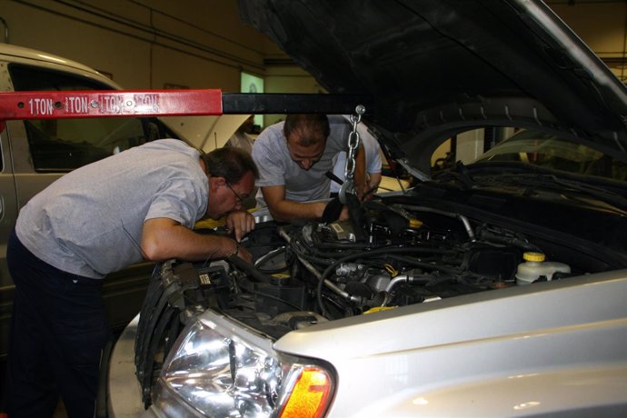 Dos hombres revisan un coche en un taller