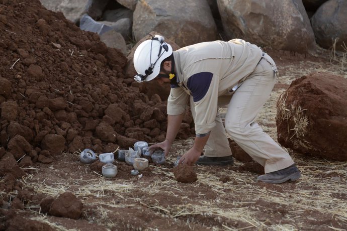 Un miembro de protección civil retira submunición de bomba de racimo en Idlib