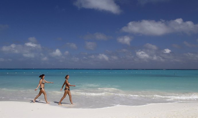 Tourists walk on Caracol beach in Cancun playa