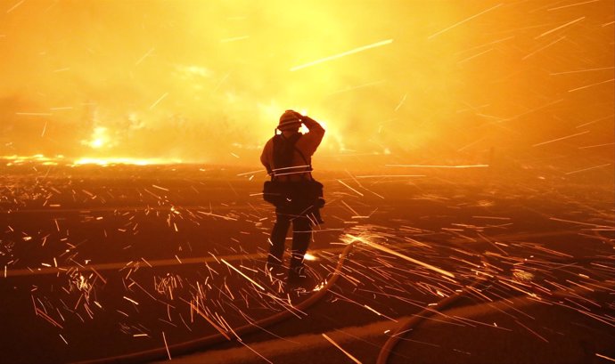 Fire photographer Tod Sudmeier gets hit with flying embers from strong winds at 