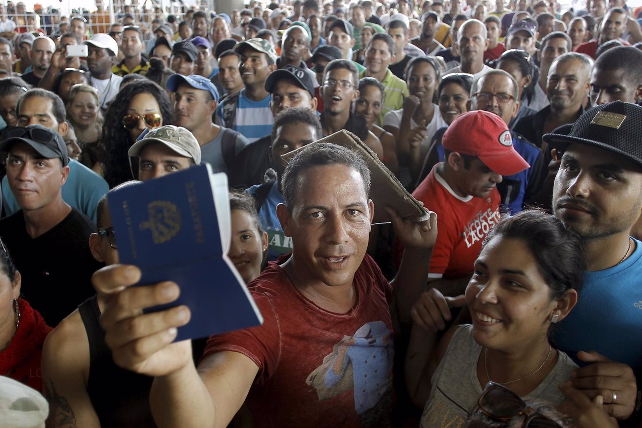 A Cuban migrant man receives his passport with the visa granted by the immigrati