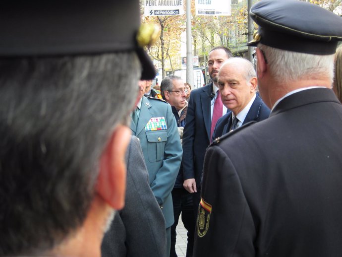 El ministro del Interior, Jorge Fernández Díaz, ante dos policías nacionales