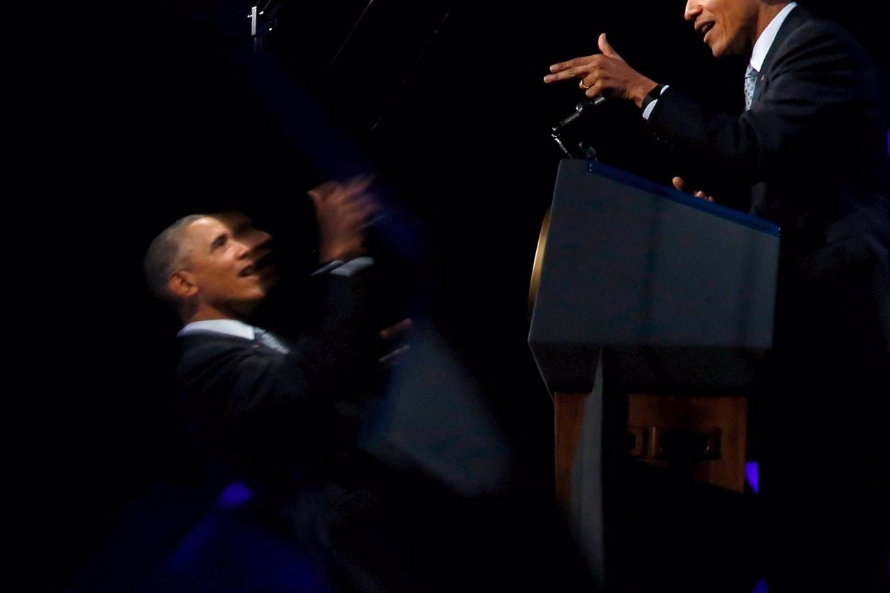 Obama is reflected in a stage-side television monitor as he delivers remarks abo