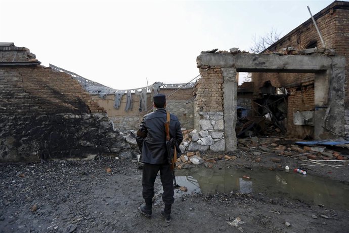 An Afghan policeman stands guard in front of a French restaurant  "Le Jardin" af