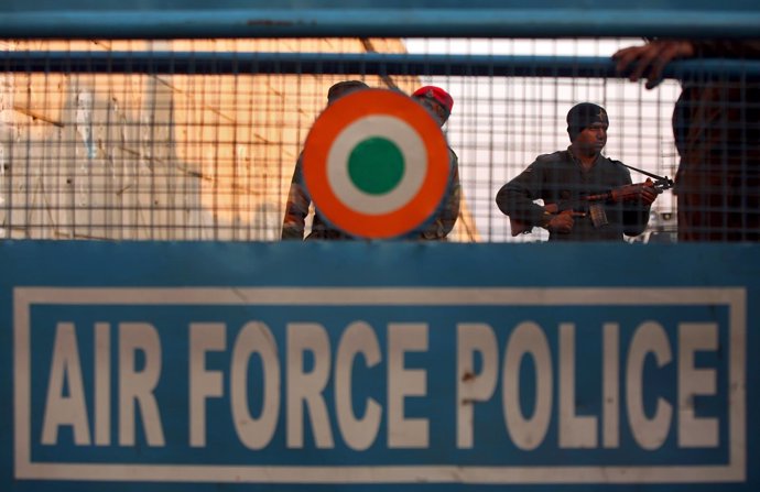 An Indian security personnel stands guard next to a barricade outside IAF base a
