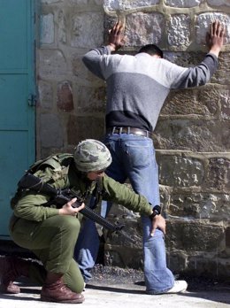 Un soldado israelí registra a un palestino en Hebrón