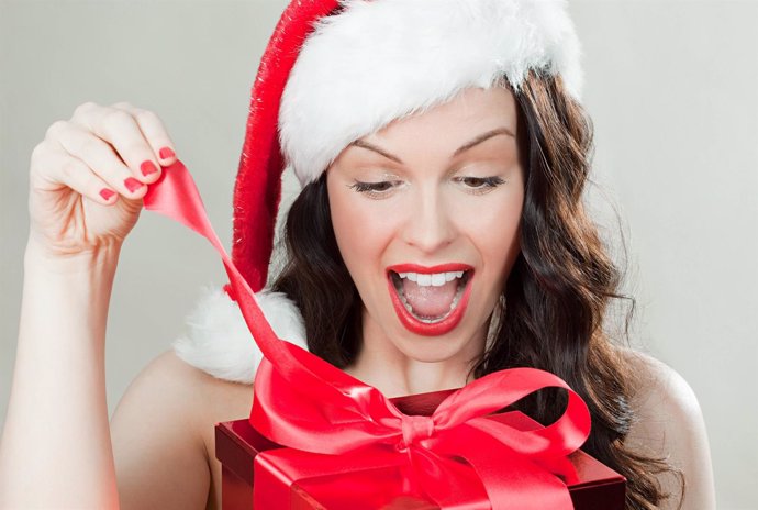 Mujer abriendo regalo de Navidad