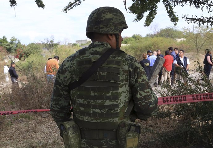 A soldier stands guard near at a crime scene where the newly installed mayor Gis