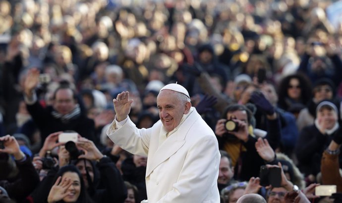 Pope Francis waves as he arrives to lead the weekly audience in Saint Peter's Sq