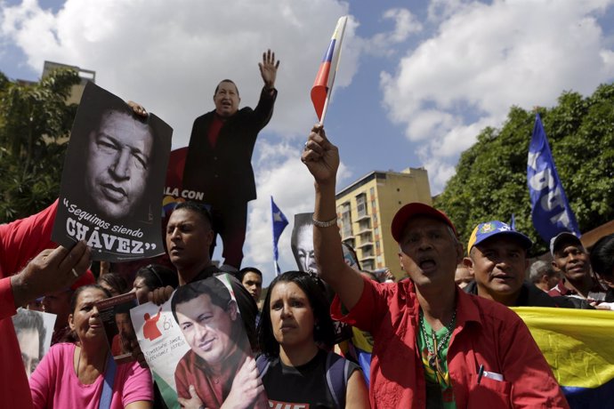 Supporters of Venezuela's President Nicolas Maduro hold up photographs of Venezu