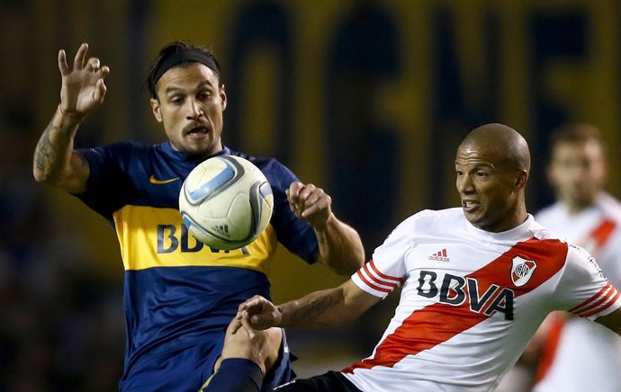 Daniel Osvaldo, de Boca, con Carlos Sánchez, de River Plate, pelean por un balón