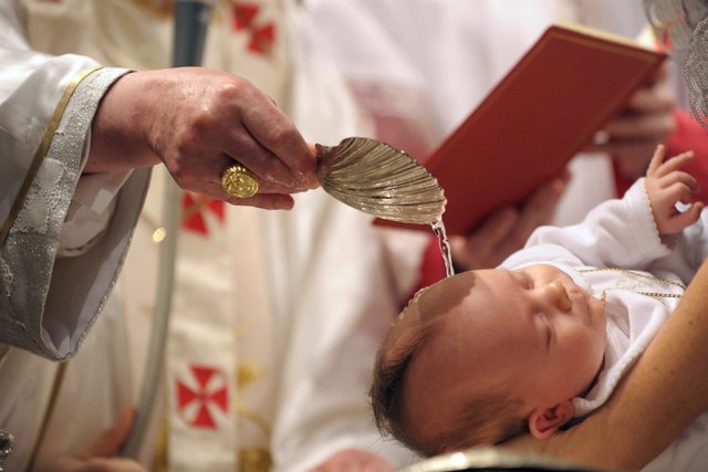 Pope Benedict XVI baptises a baby during a mass in Sistine Chapel at the Vatican