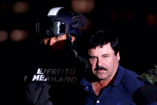 Joaquin "El Chapo" Guzman is escorted by soldiers during a presentation at the h