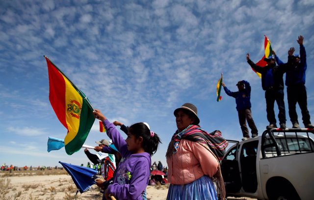 People cheer and wave Bolivian national flags as they watch the sixth stage in t