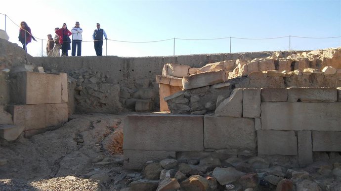 Varias personas observan la muralla norte del yacimiento ibero-romano de Castulo
