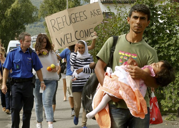 Un agente de Policía suizo acompaña a refugiados sirios