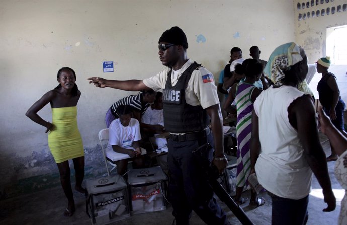Policía Nacional dice a una mujer que dejen que las urnas en Haití