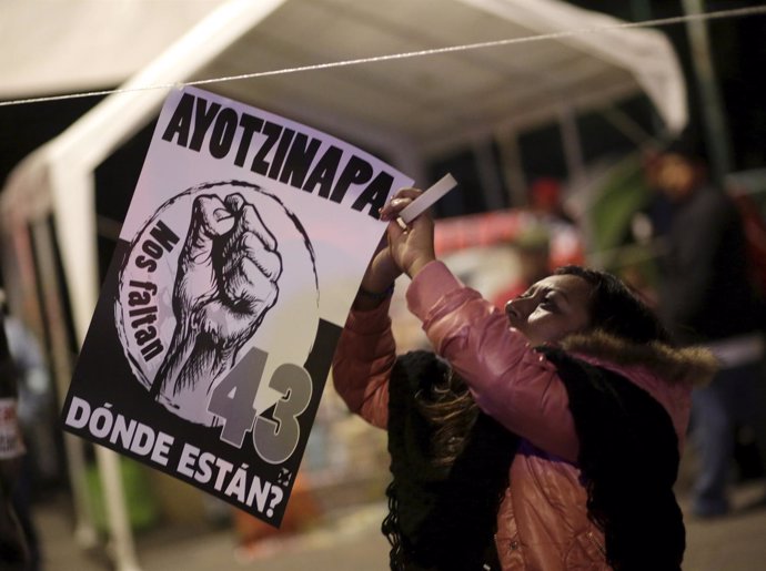 A demonstrator hangs a placard at a sit-in protest near the Los Pinos presidenti