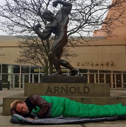 Arnold durmiendo bajo una estatua en su honor