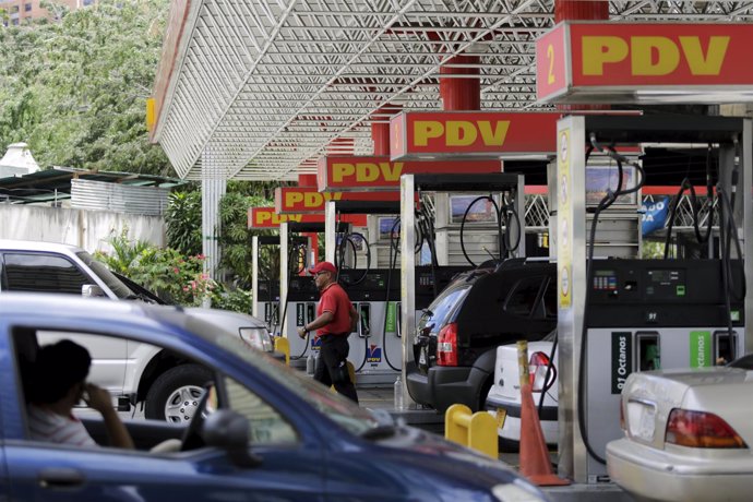 A worker walks at a gas station of PDVSA in Caracas