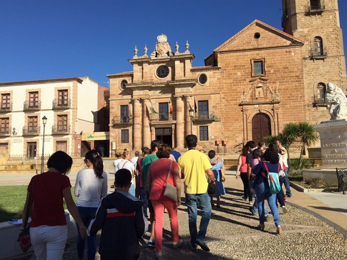 Un grupo de visitantes en La Carolina, con el Palacio del Intendente al fondo.
