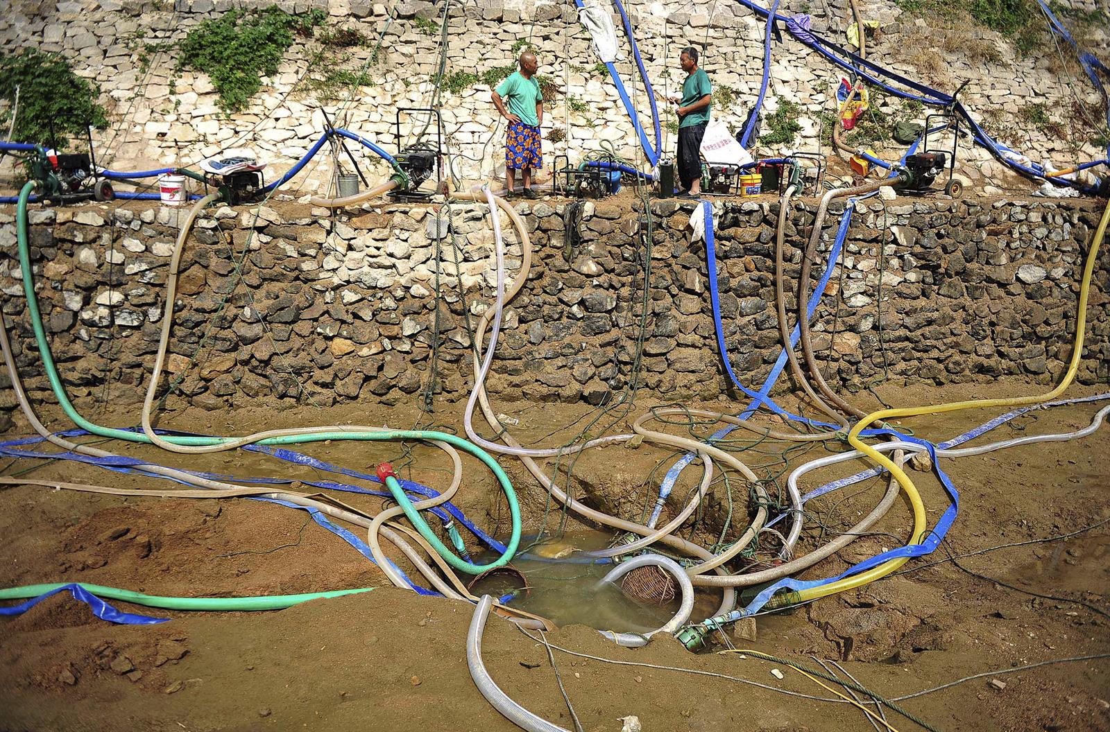 Hombres recogen agua en China 