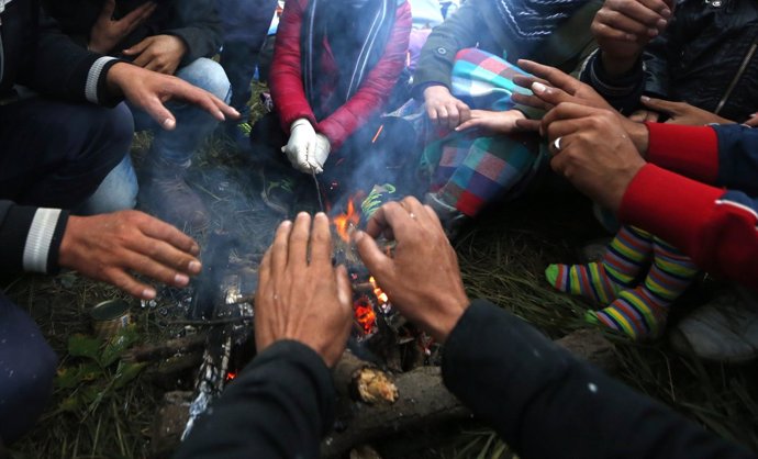 Refugiados calentándose las manos en Eslovenia