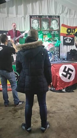 Esvástica y presunto neonazi de espaldas