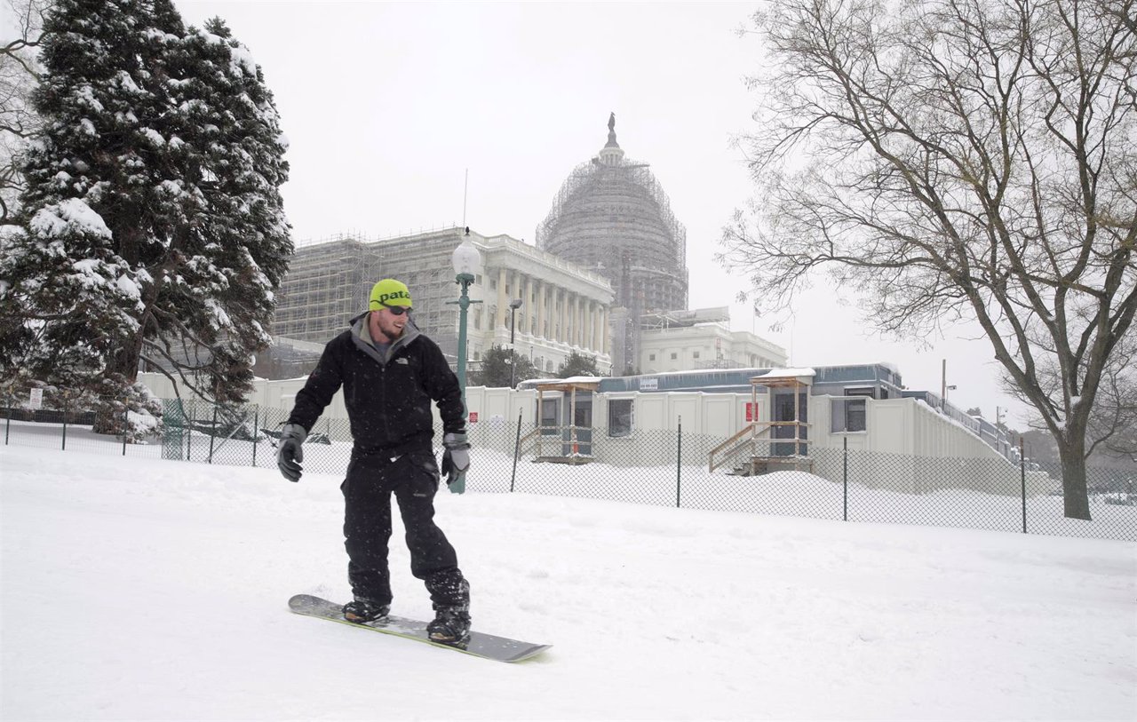 A man snowboards past the U.S. Capitol during a winter storm in Washington