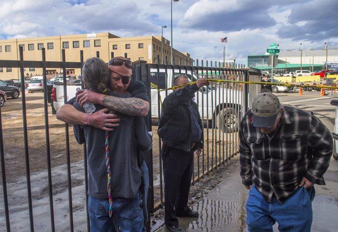 Men hug after a shooting at a motorcycle expo in Denver, Colorado