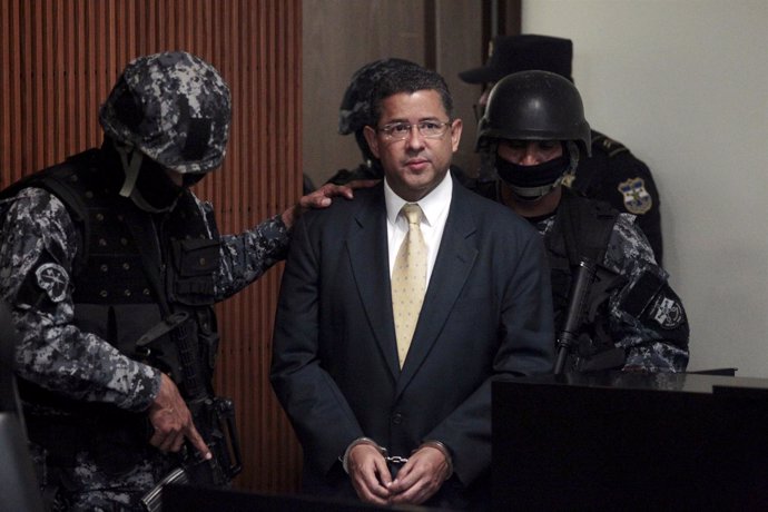 El Salvador's former president Francisco Flores stands, guarded by police office