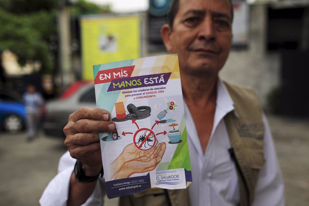 A health worker shows a flier used to explain people how to prevent Dengue, Chik