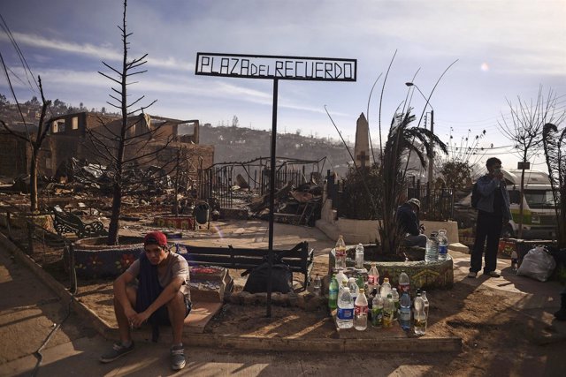 A resident, whose home was damaged by a major fire, sits in Memory Square in the