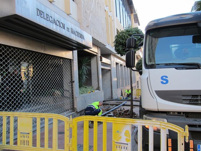 Operarios de Aguas de Huelva trabajan en un avería en el edificio de Hacienda. 