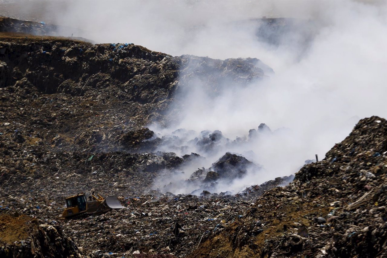 A bulldozer works next to a fire at the Santa Marta garbage dump at Talagante to