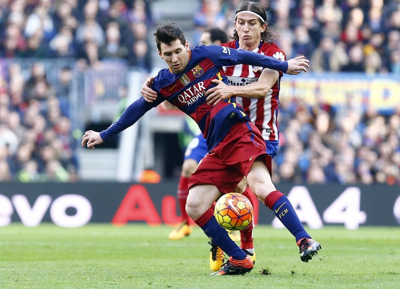 Filipe Luis y Messi pugnan por un balón 