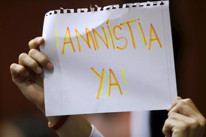 An opposition supporter holds a sign that reads "Amnesty  now" during a session 