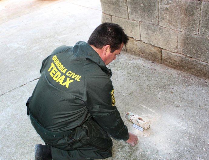 Un agente de la Guardia Civil inspecciona un proyectil de la Guerra Civil