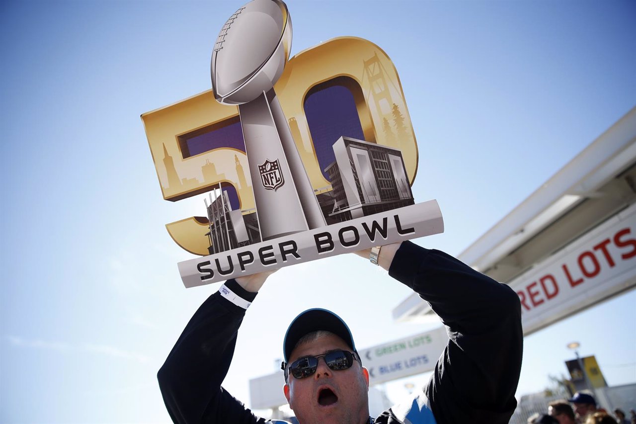 A fan carries a Super Bowl 50 sign outside Levi Stadium ahead of the NFL's Super