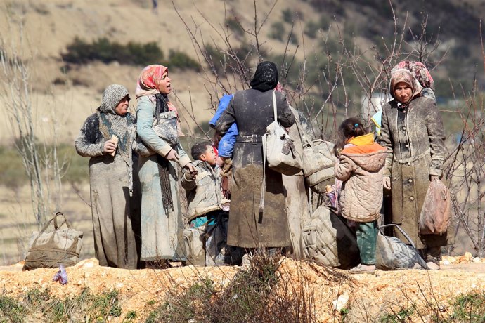 Sirios cubiertos de lodo esperan a cruzar hacia Turquía en Latakia